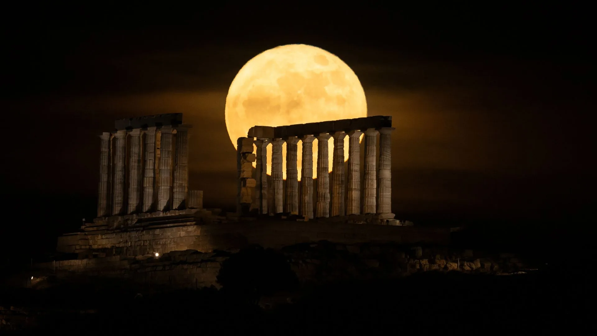 The Blue Moon rises over the Temple of Poseidon in Greece. Photo by Costas Baltas/Anadolu via Getty Images